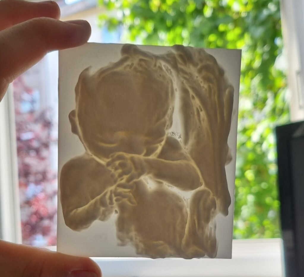 Ein liebevoll in 3D gedrucktes Modell, das auf einer Ultraschallaufnahme beruht, gehalten in zwei Händen.